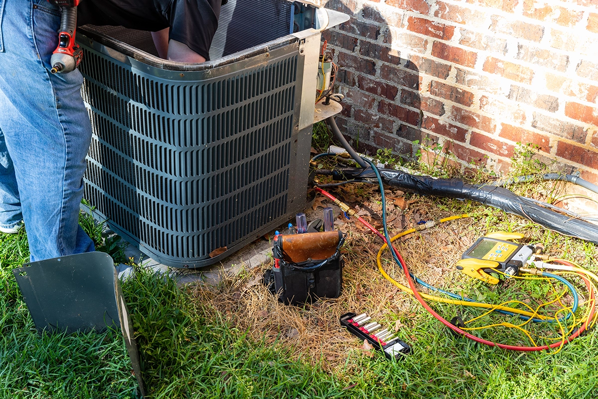 Technician performing Las Vegas air conditioning repair on an outdoor AC unit