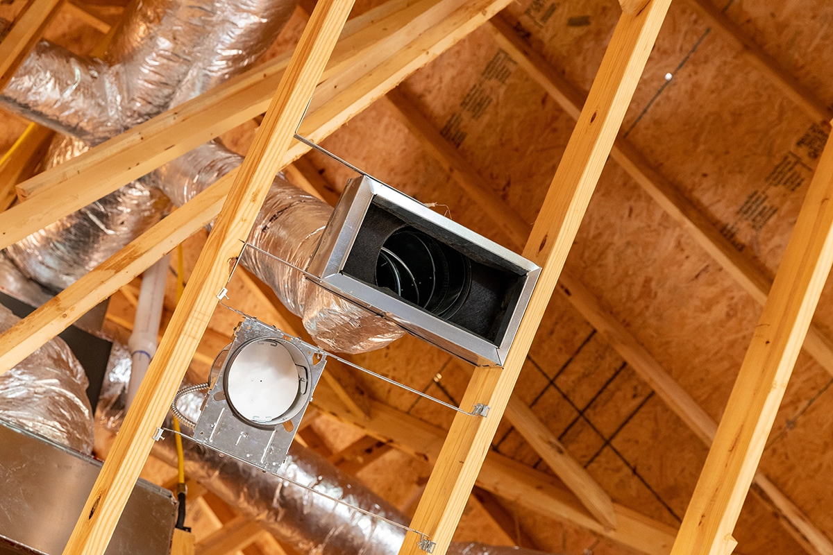 HVAC ductwork installed in an attic showing insulated ducts, vent connections, and residential airflow components