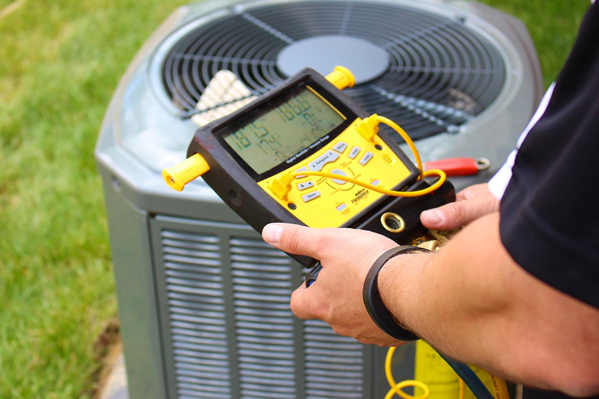HVAC technician diagnosing an AC not blowing cold air at an outdoor condenser unit