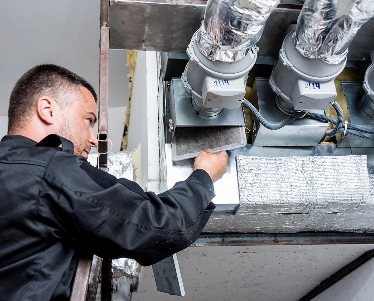 Technician inspecting HVAC filtration while explaining how air purifiers work