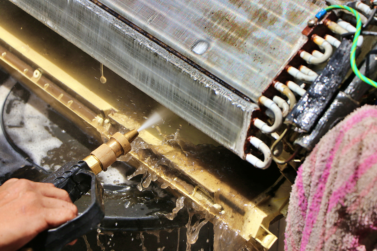 Air conditioner evaporator coil being cleaned during professional HVAC maintenance